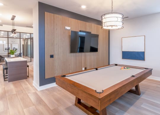 a pool table in a clubhouse with a tv on the wall