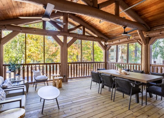 a screened in porch with a dining table and chairs at Birchwood Apartment Homes in Maple Grove, MN