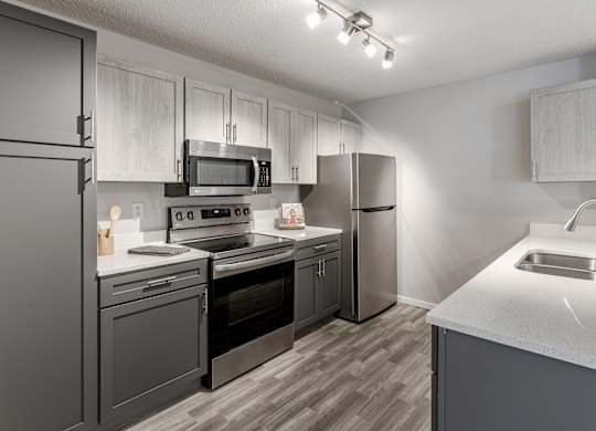 our spacious kitchen is equipped with stainless steel appliances and white quartz counter tops