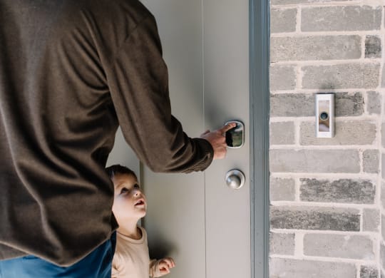 a man is knocking on a door with a child looking up at him