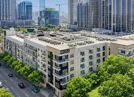 A view of a city with a building named Moda in the foreground.