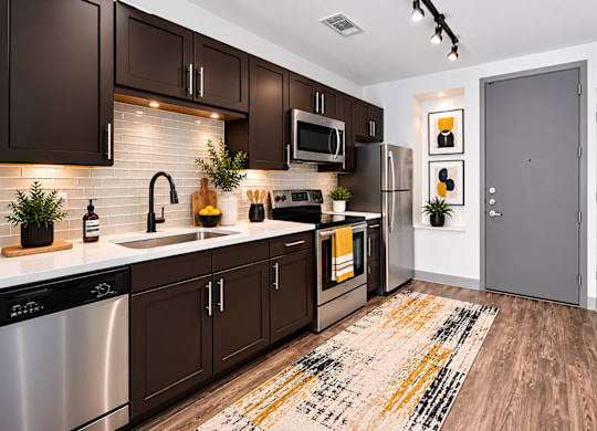 A kitchen with dark brown cabinets at Markethaus 3700 in Plano Texas