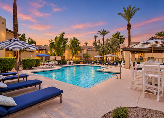 A poolside area with lounge chairs and umbrellas.