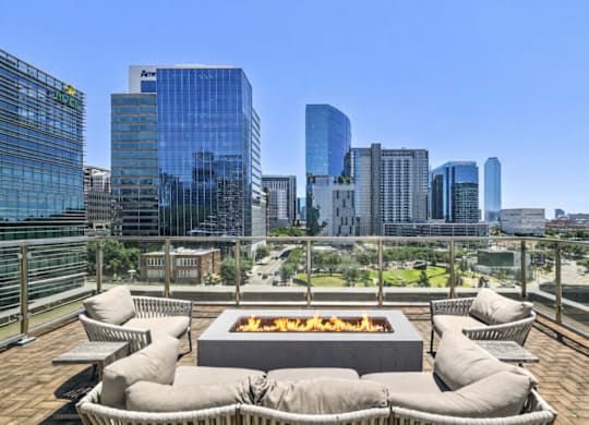 A fire pit sits in the middle of a patio with bean bag chairs around it.