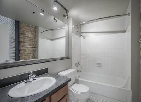 A bathroom with a white toilet, sink, and bathtub.