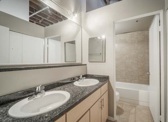 A bathroom with two sinks and a shower.