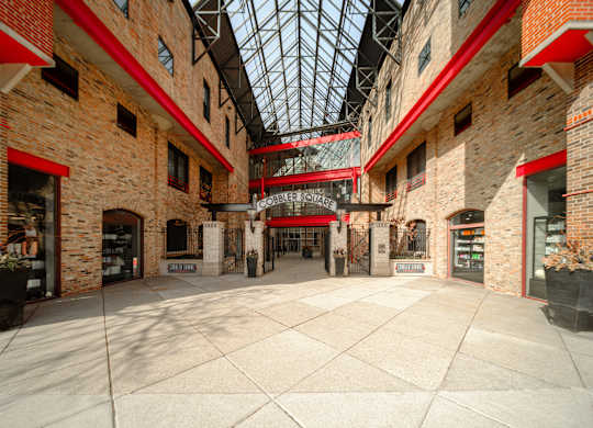 The interior of a building with a glass roof and brick walls.