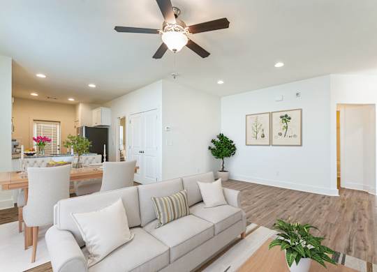 A living room with a white couch and a ceiling fan.