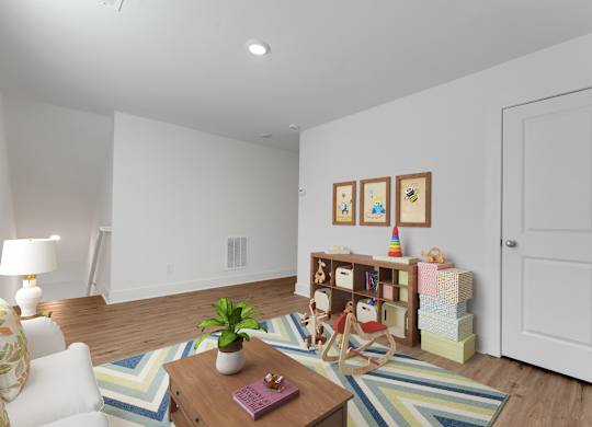 A living room with a white couch, a wooden coffee table, and a striped rug.