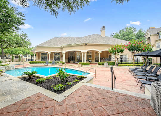 swimming pool and a patio with chairs at St Moritz in Dallas Texas
