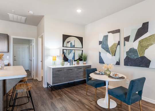 A dining room with a white table and blue chairs.