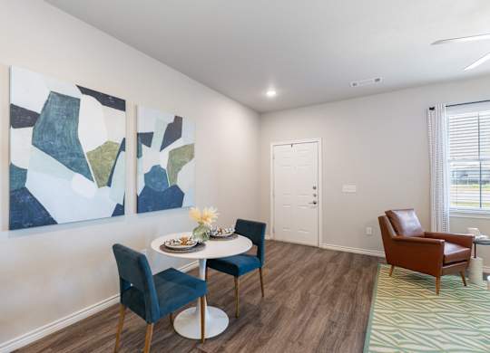 A dining room with a white table and chairs.