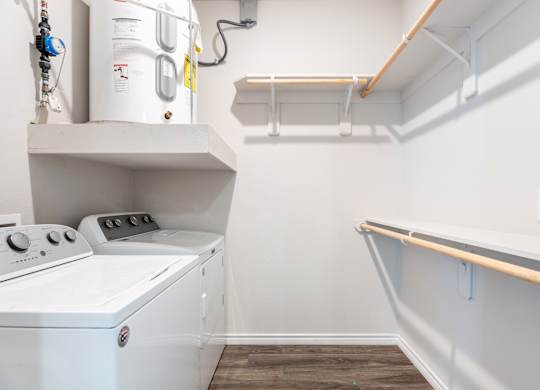 A white washing machine is sitting in a small laundry room.