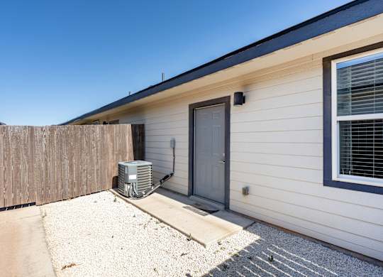 A house with a grey door and a window with blinds.