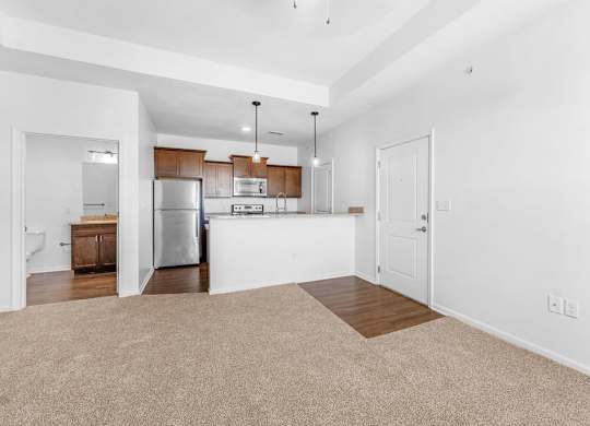 A kitchen with white walls and a refrigerator.