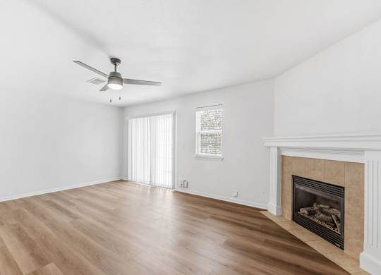A room with a fireplace and a ceiling fan.