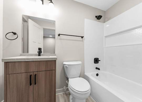 A white bathroom with a toilet, sink, and bathtub.