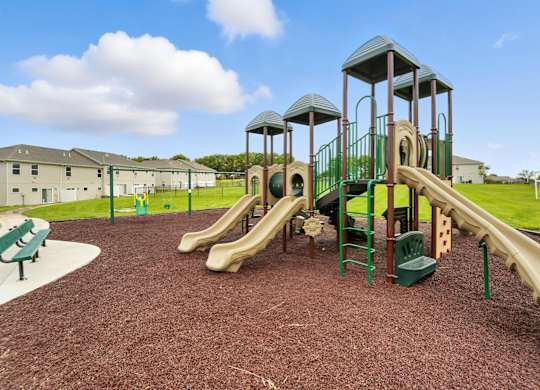 A playground with a green slide and a yellow slide.