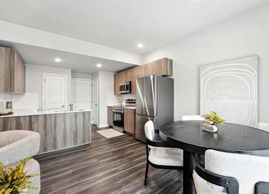 A modern kitchen with a dining table set for two.