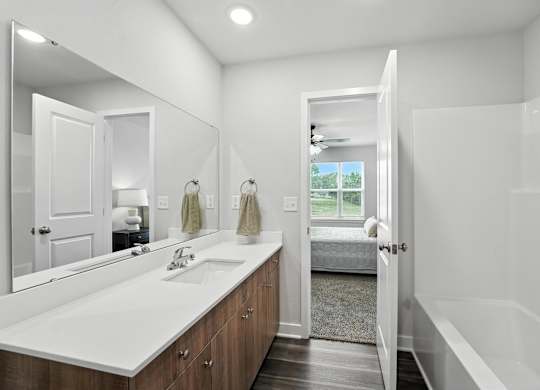 A bathroom with a white sink and mirror.