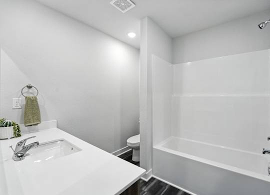 A white bathroom with a sink, toilet, and bathtub.