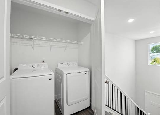A white laundry room with a washer and dryer.