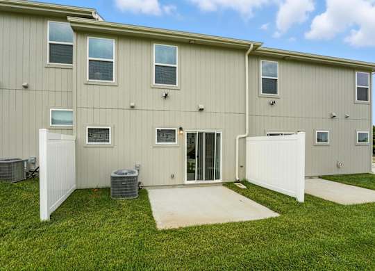 A building with a white fence and a door is shown.