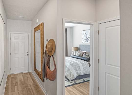 A hallway with a mirror and a hat hanging on it.