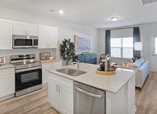 A modern kitchen with white cabinets and stainless steel appliances.