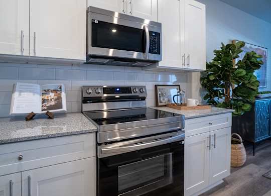 A modern kitchen with a stainless steel oven and microwave.