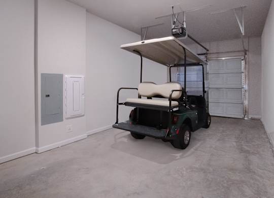 A golf cart is parked in a garage.