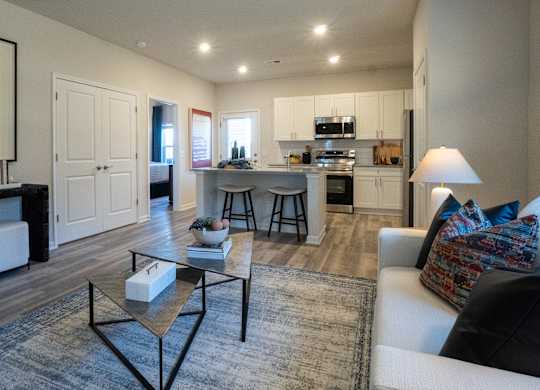 A modern living room with a white sofa and a coffee table in the center.
