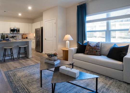 A well-lit living room with a white couch and a coffee table.