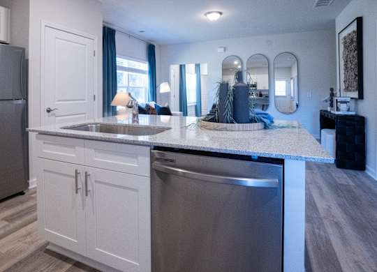 A modern kitchen with a stainless steel refrigerator and dishwasher.
