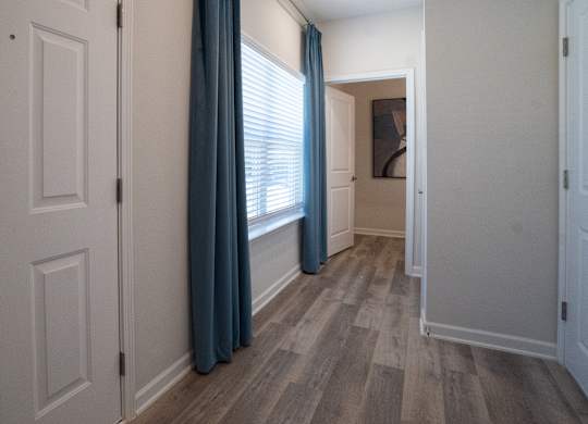 A hallway with white doors and a blue curtain.