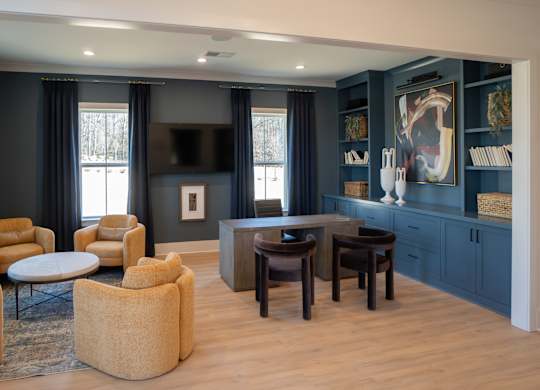 A living room with a television, chairs, and a table.