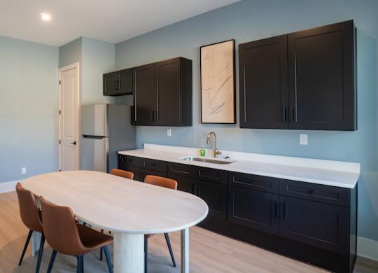 A kitchen with a table and chairs in the middle of the room.