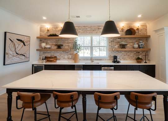 A kitchen with a table and chairs in front of a brick wall.
