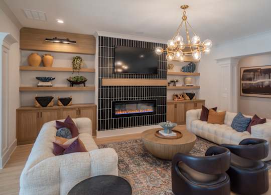 A living room with a fireplace and a chandelier.