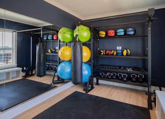 A gym with a variety of equipment including kettlebells and exercise balls.