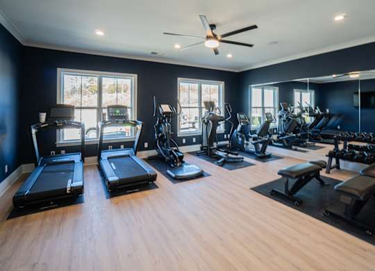 A spacious gym with treadmills, elliptical machines, and other exercise equipment.