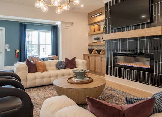 A living room with a fireplace and a flat screen TV mounted above it.
