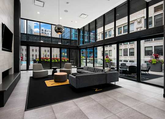 Modern living room with a grey sofa and a yellow rug.