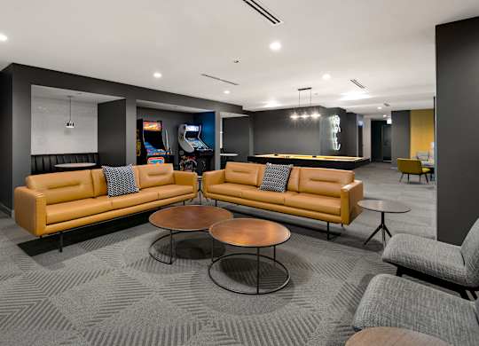 A modern lounge area with a large sectional sofa and a coffee table.