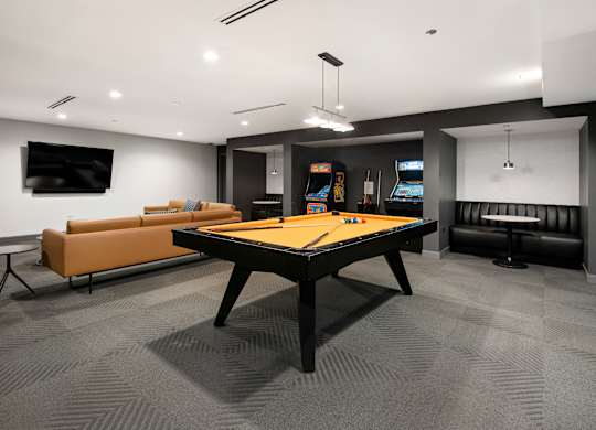 A room with a pool table and a couch.