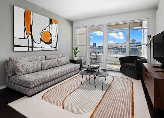a living room with a couch and a tv and a balcony