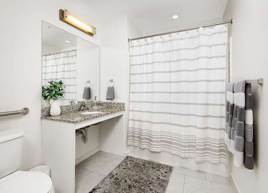 a bathroom with a shower and a sink and a toilet
