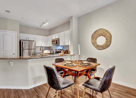 A kitchen with a dining table and chairs.
