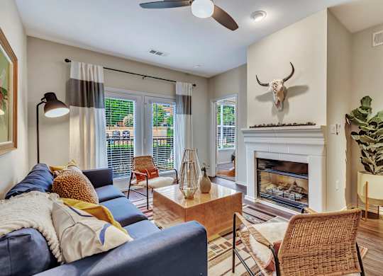 A living room with a blue couch and a fireplace.