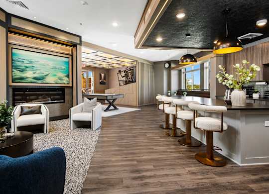 A modern living room with a bar area and a painting on the wall.